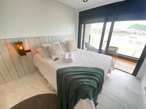 a bedroom with a large bed with a large window at BALUARTE POUSADA in Torres