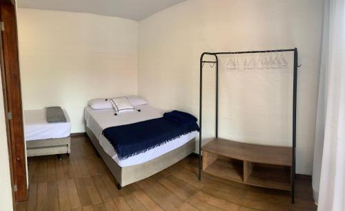 um pequeno quarto com 2 camas e um espelho em Pousada Inn Nature em Palhoça