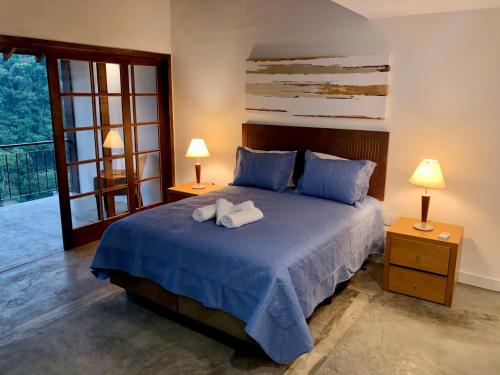 1 dormitorio con 1 cama con 2 toallas en Pousada Golf Village, en Itaipava