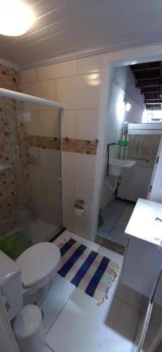 a bathroom with a toilet and a shower and a sink at Loft e Vila da Praia Studios Ilha Grande in Abraão
