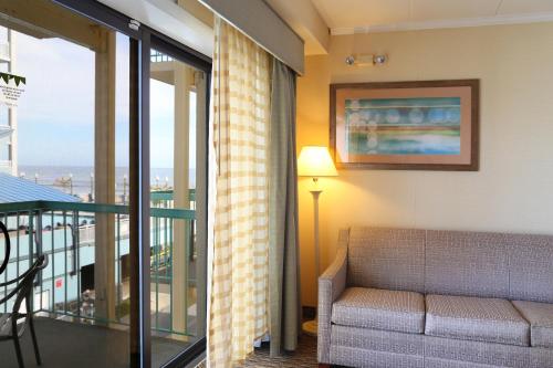 a living room with a couch and a balcony at Quality Inn Boardwalk in Ocean City