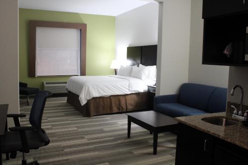 a hotel room with a bed and a couch at Holiday Inn Express and Suites Heber Springs by IHG in Heber Springs