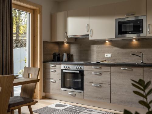 a kitchen with a stove and a sink at Appartements Bichl ,Haus Ausblick in Wenns