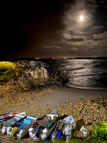 una vista de la playa por la noche con luna llena en Baleal waterfront en Baleal