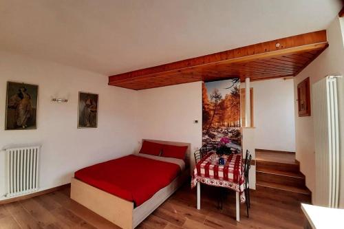 a bedroom with a red bed and a window at Appartamento vicino al centro da Lori in Bormio