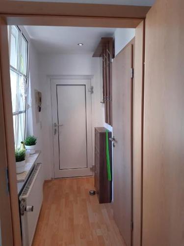 a hallway with a refrigerator and a door in a room at Ferienwohnung Salzmannhaus in Zschopau