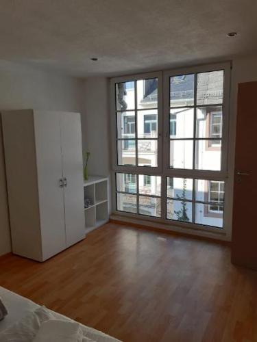 an empty room with a large window and a bedroom at Ferienwohnung Salzmannhaus in Zschopau