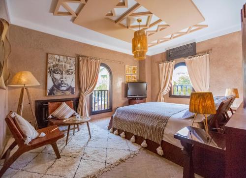 1 dormitorio con 1 cama, TV y 2 ventanas en Villa Malika Silvana, en Marrakech