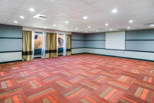 a large room with blue walls and a wooden floor at Aspire Hotel and Suites in Gettysburg