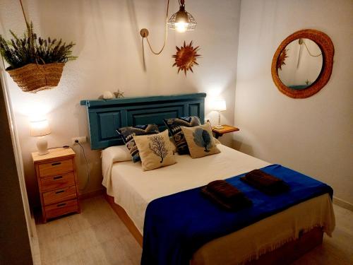 a bedroom with a bed with a blue headboard and a mirror at Casa Salá, alojamiento con encanto en Vera Natura in Vera