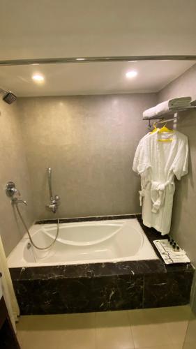 a bathroom with a bath tub with a sink at Gis Select Banjara Hill in Hyderabad