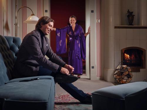 a man and a woman standing in a living room at Villa Ammende Restaurant and Hotel in Pärnu
