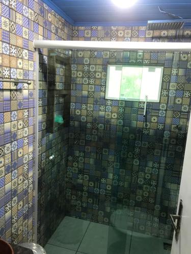 a bathroom with a shower with a glass door at Casa colonial azul Santuário Bellatrix in Ribeirão Amarelo