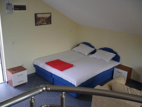 a bedroom with a bed with a red blanket on it at Crypto Hills Montenegro in Herceg-Novi