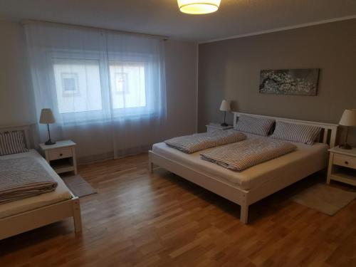 a bedroom with two beds and a window at Ihre Ferienwohnung in 67454 Haßloch - Pfalz in Haßloch