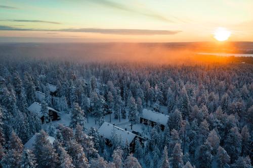 an aerial view of a snow covered forest at sunset at Tilhi Chalet in Rovaniemi