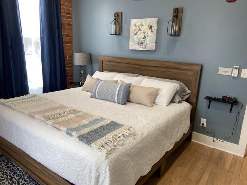 a bedroom with a large bed with blue walls at Brickhouse Loft - a boutique hotel in Martinsville