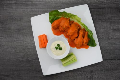 a plate of food with carrots celery and a dipping sauce at Hotel Jatay in Tijuana