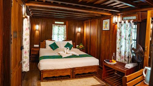 1 dormitorio con 1 cama en una habitación de madera en Kalpavanam Heritage Resort, en Thekkady
