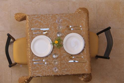 a table with two plates and forks and knives at Dar Sitti Aziza in Bethlehem