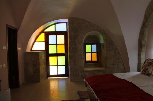 a bedroom with a bed and two stained glass windows at Dar Sitti Aziza in Bethlehem
