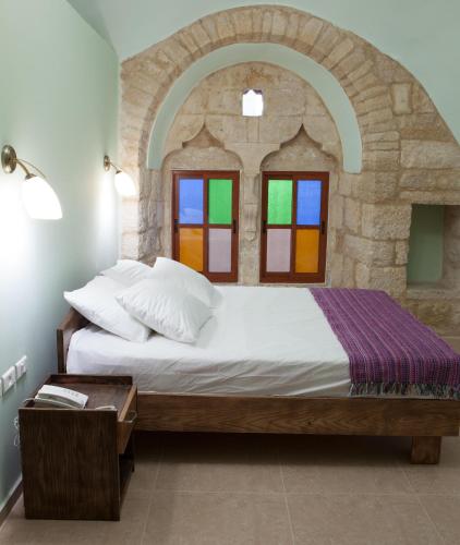 a bedroom with a large bed with a stone wall at Dar Sitti Aziza in Bethlehem
