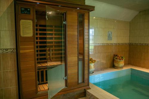a swimming pool with a glass shower in a bathroom at Cantervilla Castle in Otepää