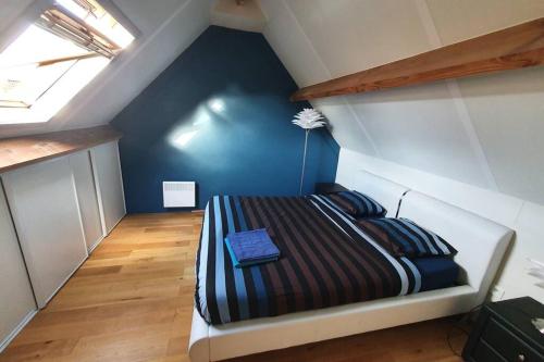 a bedroom with a bed in a attic at Maison au bord de lac in Ghyvelde