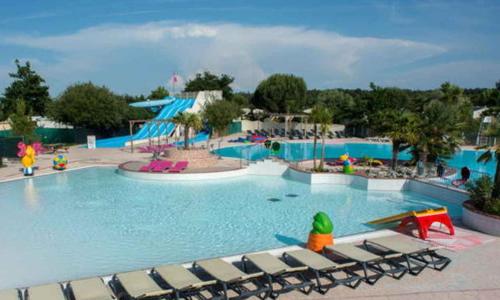 - une grande piscine avec des chaises dans un complexe dans l'établissement MH 6-8p - tt équipé - WIFI inclus - camping 4e bord de lac, à Gastes