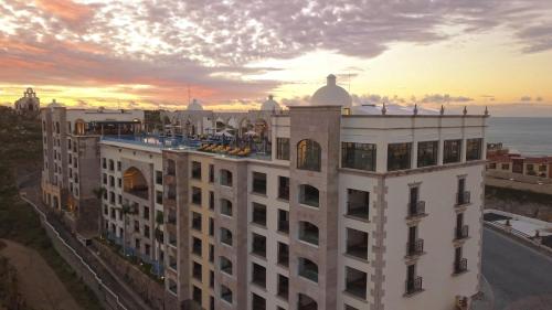 a white building with a sunset in the background at Vista Encantada Resort & Spa Residences, A La Carte All Inclusive Optional in Cabo San Lucas