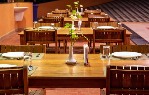 a wooden table with a vase with a plant on it at Kalpavanam Heritage Resort in Thekkady