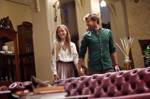 a man and a woman standing next to a couch at Villa Ammende Restaurant and Hotel in Pärnu