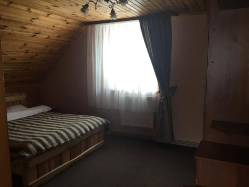 a bedroom with a bed and a window at Guest house Zatishniy dvir in Yaremche