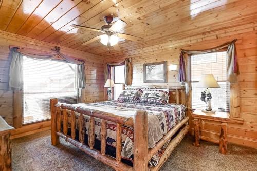 a log cabin bedroom with a wooden bed and windows at Mountain Top View Retreat in Sevierville