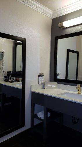 a bathroom with a sink and a large mirror at Hotel Aria in Mountain View