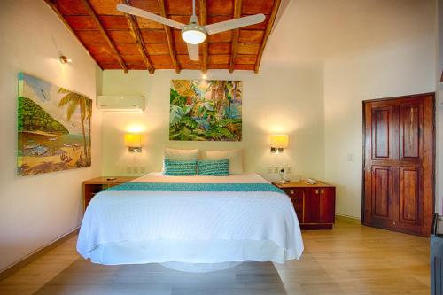 a bedroom with a white bed and a ceiling at Villa Lala Boutique Hotel Adults Only in Puerto Vallarta