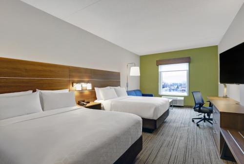 a hotel room with two beds and a television at Holiday Inn Express & Suites - Collingwood in Collingwood