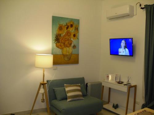 ein Wohnzimmer mit einem Stuhl und einem Gemälde an der Wand in der Unterkunft GELSO HOME in Neapel