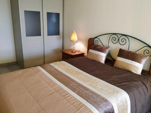a bedroom with a large bed with a lamp on a table at Home Aveiro Ria in Aveiro