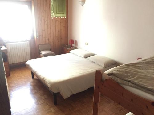 una camera con due letti e una finestra di residenza in zona Pontedilegno T02034 a Villa dʼAllegno