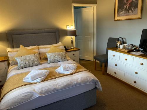 a bedroom with a bed with a desk and a television at The Royal Oak Inn in Withypool