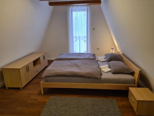 a bedroom with a bed with a dresser and a window at KUĆA NENO in Vlasic