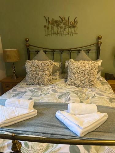 a bed with two towels sitting on top of it at The Royal Oak Inn in Withypool