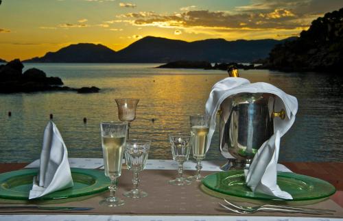 a table with glasses and a tea kettle on top of the water at Hotel Fiascherino in Lerici
