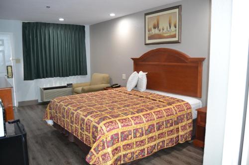 a hotel room with a bed and a green window at Deluxe Inn Irving in Irving