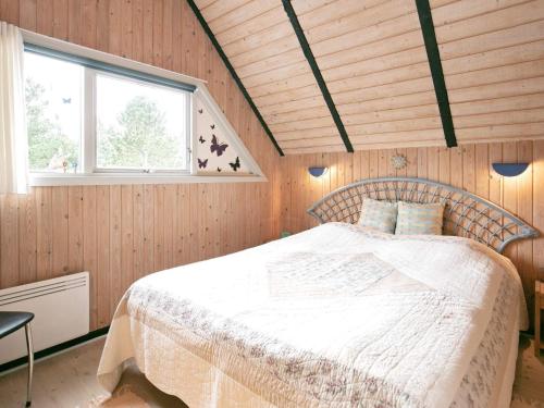 ブラーバンドにあるThree-Bedroom Holiday home in Blåvand 69の木製の壁のベッドルーム1室(ベッド1台付)