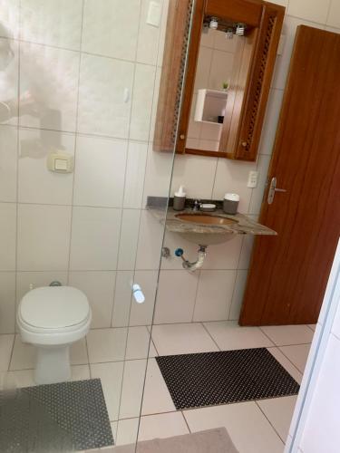a bathroom with a toilet and a glass shower at Sunset Cacupé in Florianópolis