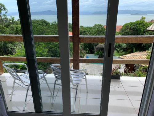 Un balcón con sillas y vistas al océano. en Sunset Cacupé en Florianópolis