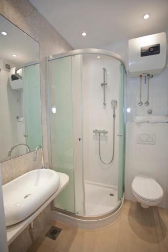 a bathroom with a shower and a toilet and a sink at Villa Makarana Apartments in Makarska