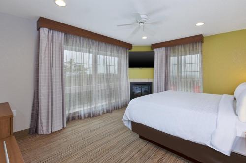 a bedroom with a bed and two large windows at Holiday Inn Express Hotel & Suites Petoskey by IHG in Petoskey